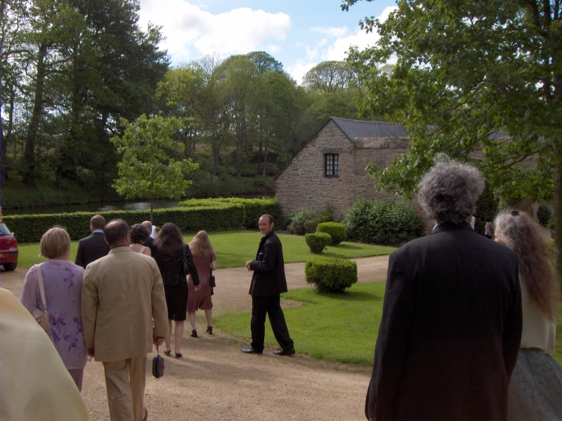Guests follow the wedding couple towards the Manoir